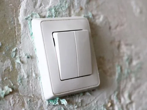 The white switch on the old plastered wall Foto stock