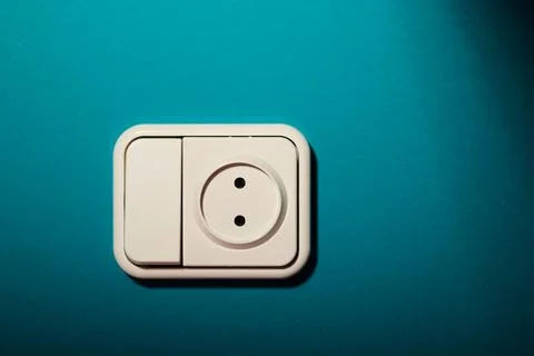 White switch socket on a green wall. Stock Photos