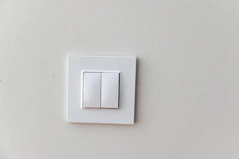 A white switch on a wall with a white background Stock Photos