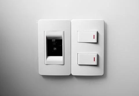 White switch on a white wall with two switches and one common switch. Stock Photos
