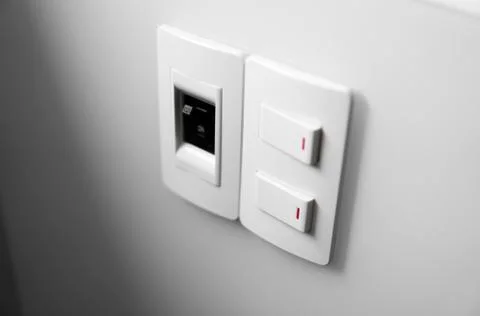 White switch on a white wall with two switches and one common switch. Stock Photos
