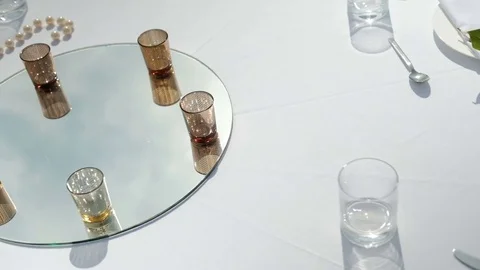 White table with drinks on mirror for banquet on fresh air outdoors Stock Footage 76479849
