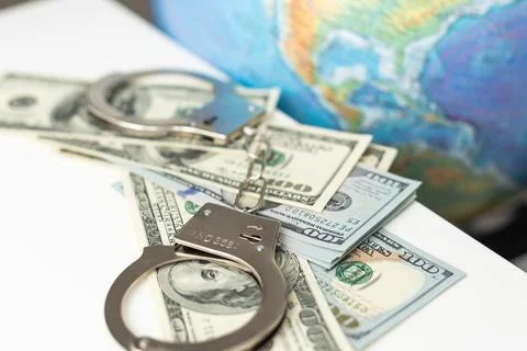 On a white table, handcuffs and a globe. Near a copy space. Cybercrime concept. 写真素材