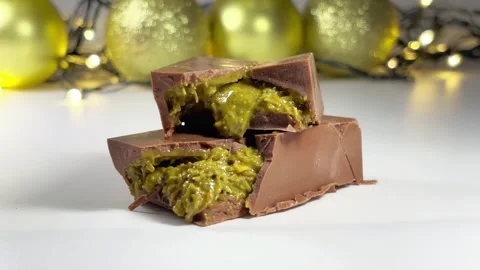 On a white table lies Dubai chocolate with a garland and Christmas balls Stock Footage 309454302
