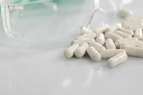 On the white table next to the protective glasses lie scattered tablets with  Stock-Fotos