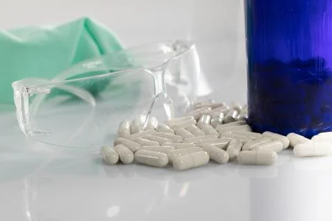 On the white table next to the protective glasses lie scattered tablets with  Stock-Fotos