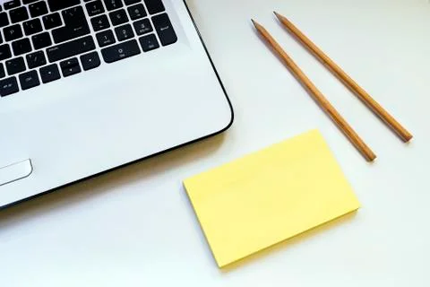 On a white table notebook two pencils and a sticker Stock Photos