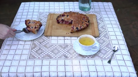 White table with a pie, tea cup and . Wooman Stock Footage 141015836