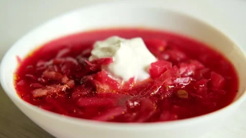 On a white table a plate with homemade borscht and sour cream. D Stock Footage 282960637