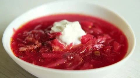 On a white table a plate with homemade borscht and sour cream.  Stock Footage 282960644
