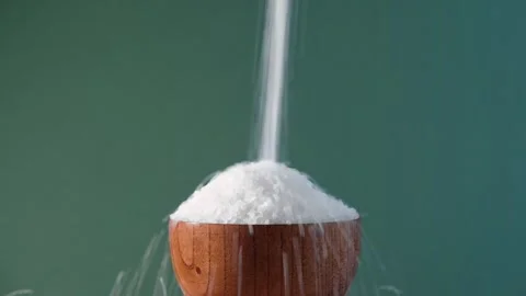 White table salt granules falling into a pile. Wood bowl. Grained sea salt Vidéo 249736346