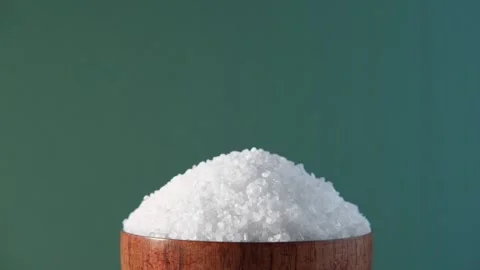 White table salt granules falling into a pile. Wood bowl. Grained sea salt Vidéo 249736593