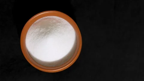 White table salt in rustic clay bowl isolated on black background Stock Footage 336646045