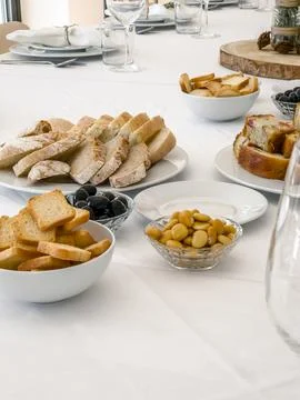 A white table is set with a selection of savory appetizers for guests Stock Photos