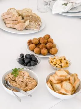 A white table is set with a selection of savory appetizers for guests Stock Photos