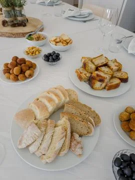 A white table is set with a selection of savory appetizers for guests Stock Photos