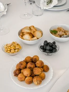 A white table is set with a selection of savory appetizers for guests Stock Photos