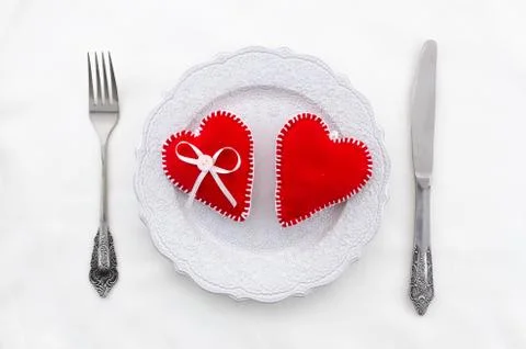 White table setting for Valentine's Day with cutlery, hearts on white table Stock Photos