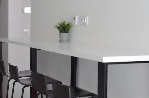 White table-shelf in a narrow kitchen. Modern interior. black chairs. Foto stock