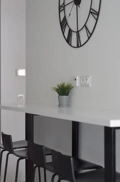 White table-shelf in a narrow kitchen. Modern interior. black chairs. Stock Photos