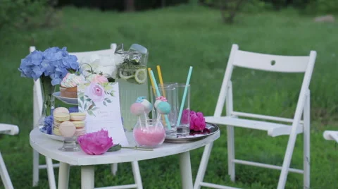 White table with sweets on nature. Wedding cakes and flowers. Sweet balls. Empty Stock Footage 61715156