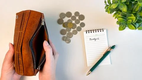 On the white table there is an empty wallet and a notebook with coins Foto stock