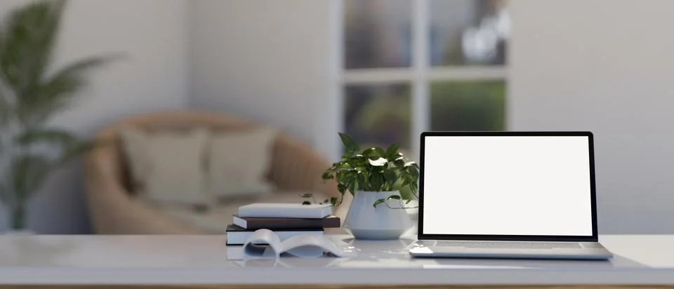 A white table with a white-screen laptop computer mockup in modern and comf.. Illustrazione stock