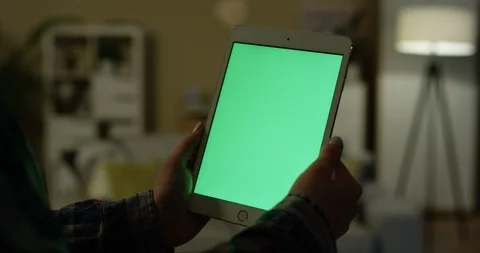 White tablet device with green screen in hands of the Caucasian woman inside the Stock Footage 104981192