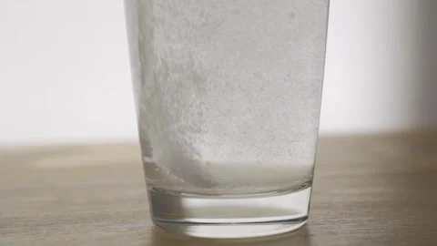 The white tablet has sunk to the bottom of the glass and dissolves in water Video stock 157681052