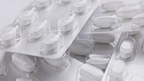 White tablet oval tablets blisters close-up looped spinning or rotating macro Stock Footage 163615245