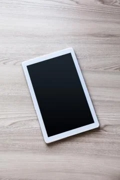White tablet pc with empty screen on wood background Stock Photos