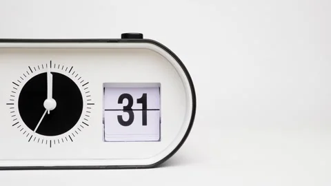 A white tabletop clock with hands and a calendar showing the number 31 Stock Footage 284349558