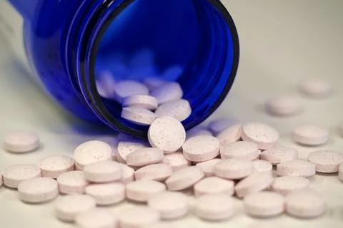 White tablets and blue container for nutritional supplements Stock Photos