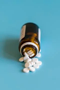 White tablets and bottle for tablets on blue background Stock Photos