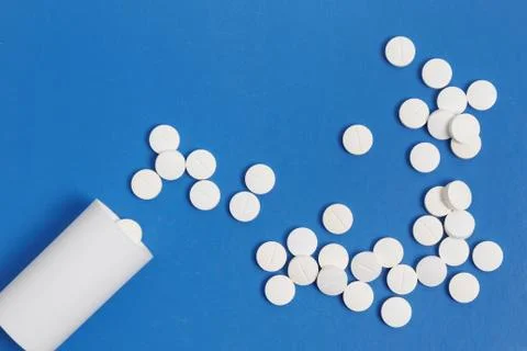White tablets and bottle for tablets on blue background Foto stock