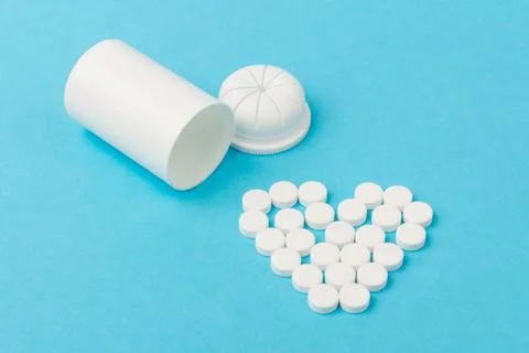 White tablets and bottle for tablets on blue background Stock Photos