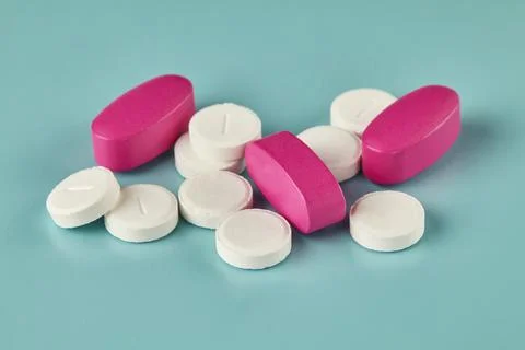 White tablets and pink caplets Stock Photos