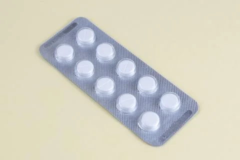 White Tablets in Blister Pack on Light Yellow Background Healthcare and Med.. Stock Photos