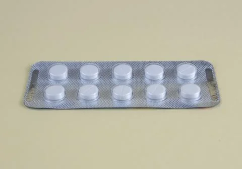 White Tablets in Blister Pack on Light Yellow Background Healthcare and Med.. Stock Photos