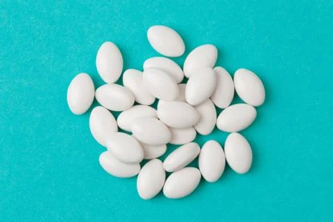 White  tablets on blue  background - Image Stock Photos