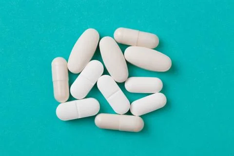 White  tablets on blue  background - Image Stock Photos