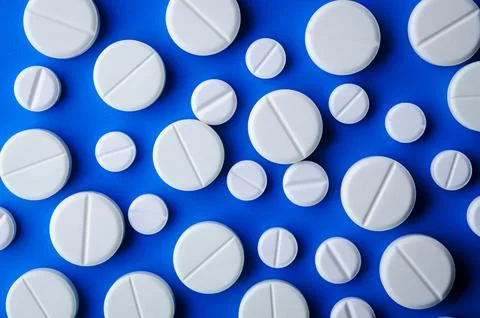 White tablets on blue background Foto stock