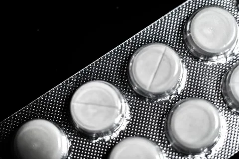 White tablets close up on a black background macro photo. Stock Photos