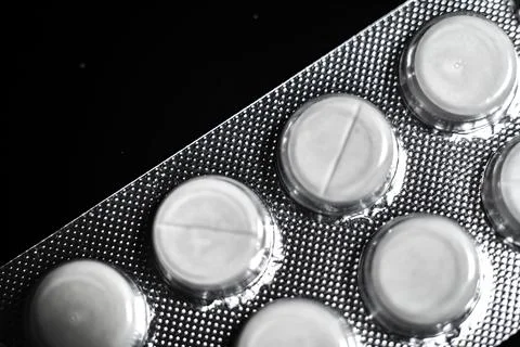 White tablets close up on a black background macro photo. Stock Photos