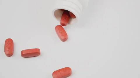 White tablets fall out of the bottle onto the table, slow motion. Antiviral drug Stock Footage 278737421