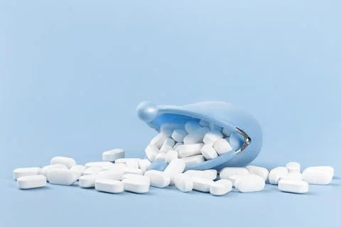 White tablets falling out of blue purse, drugs and medicine Stock Photos