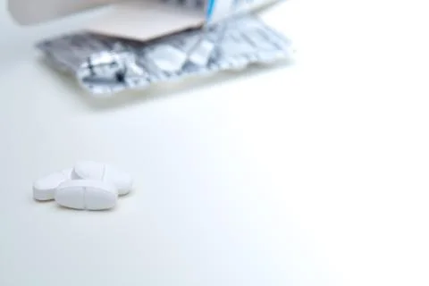 White tablets isolated on white with some pills in foreground Stock Photos
