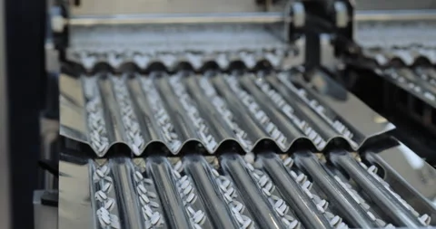 White tablets move along parallel corrugated channels on pharmaceutical line. Stock Footage 346229590