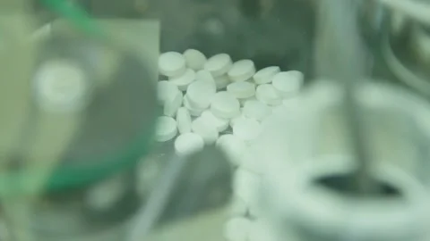 White tablets move on steel automatic line at drug manufacturing factory. close Video stock 200856084