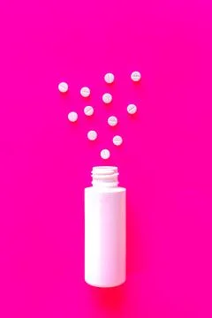 White tablets or pills with package on pink background with copy space Stock Photos